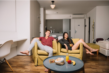 Couple sitting on armchairs in their newly furnished apartment