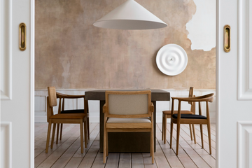 Minimalist dining room with wooden chairs and a rustic dining table.