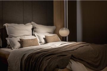 Minimalistic luxury bedroom with a king-size bed and wooden headboard.